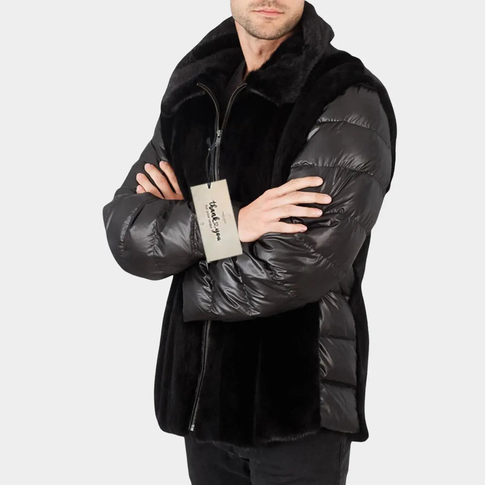 Man wearing a black puffer jacket with a brand logo on a light gray background