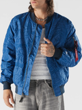 Man wearing a blue embroidered Dodgers bomber jacket with sleeve pocket and red Alpha Industries flight tag