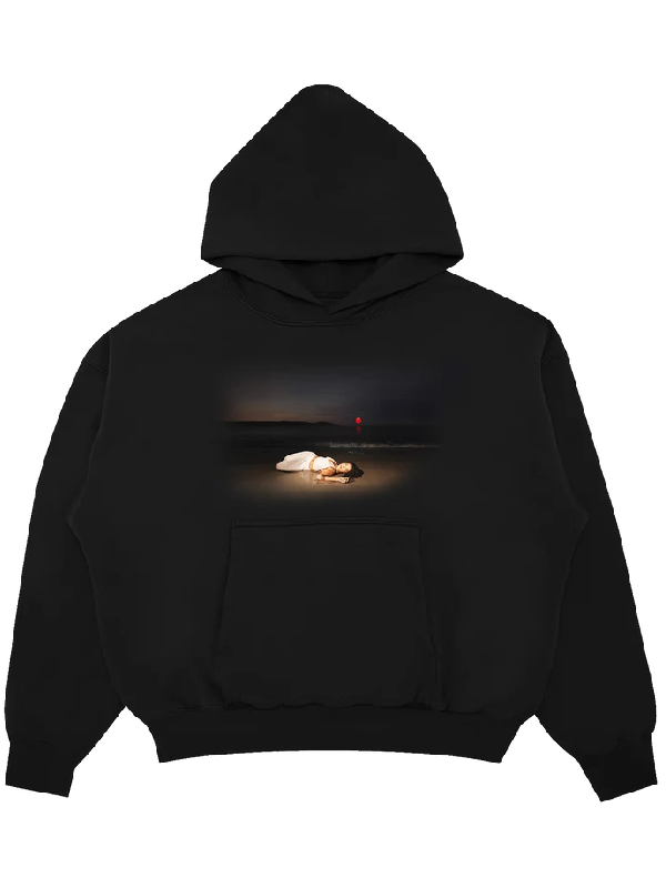 Black fleece hoodie with a sunset beach photo of a woman in white lying on the sand with a red balloon, and a front kangaroo pocket