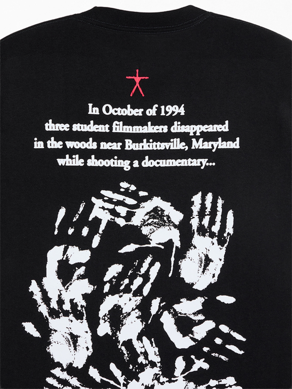 Close-up of Blair Witch tee back print showing found-footage story text and overlapping white handprints