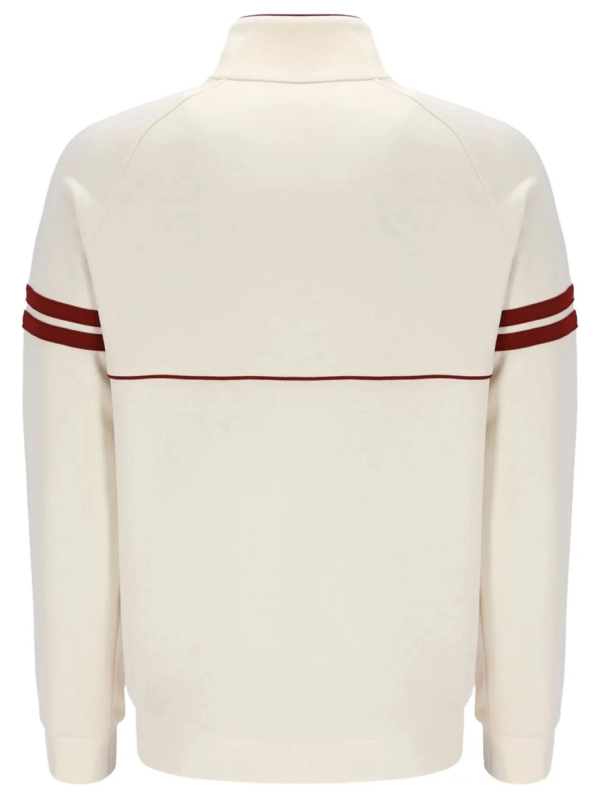 Back view of the cream track jacket showing ribbed hem and stripe detailing