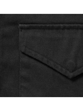 Close-up detail of the black cotton twill fabric and stitched flap pocket.